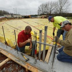 THOMAS WELLS | via DJOURNAL.COM
Hooker Construction workers John Logan, from left, Danny Carl and Roberts Stevens begin taking down the concrete forms around the base of the new storm shelter under constructin at North Pontotoc High School on Monday.