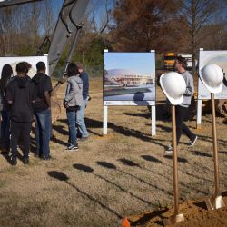 Students look at plans for the storm shelter while awaiting the groundbreaking in Tupelo, Mississippi.